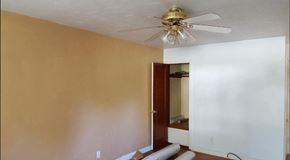 Ferguson house for rent - an empty room with a ceiling fan and a door