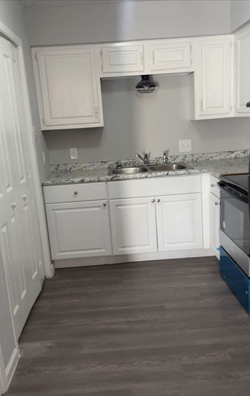 Lake Charles apartment for rent - a small kitchen with white cabinets and a wood floor