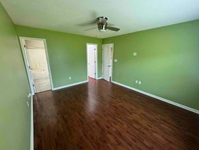 Charlotte house for rent - a empty living room with green walls and a wooden floor