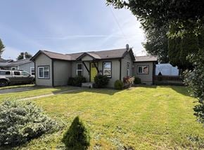 Kelso house for rent - a gray house with a yard and a yellow door