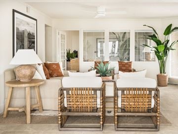 Glendale apartment for rent - A living room with a white couch, two chairs, and a table with a lamp and vase.