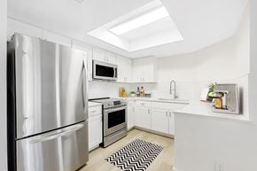 Glendale apartment for rent - A modern kitchen with a stainless steel refrigerator and white cabinets.