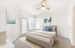 Loveland apartment for rent - A bedroom with a large bed and a ceiling fan.