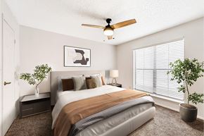 Westminster apartment for rent - A bedroom with a bed, a ceiling fan, and two potted plants.
