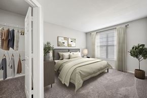 Westminster apartment for rent - A bedroom with a large bed and a wardrobe with clothes hanging on it.