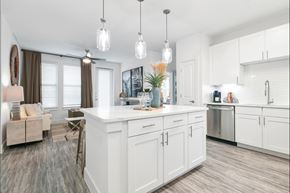 Garland apartment for rent - A kitchen with white cabinets and a wooden floor.