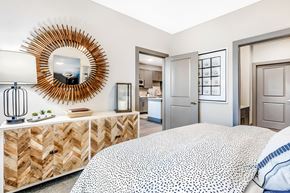 Garland apartment for rent - A bedroom with a large bed and a mirror on the wall.