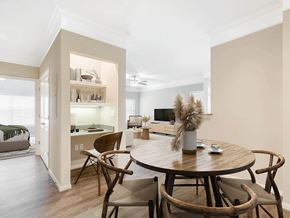 Pearland apartment for rent - A dining room with a round wooden table and chairs.