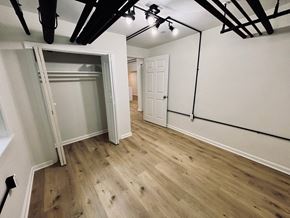 Washington apartment for rent - A room with a white door and a white wall with a wooden floor.