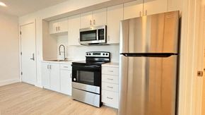Los Angeles apartment for rent - A modern kitchen with stainless steel appliances and white cabinets.