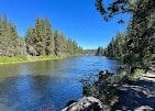 Bend apartment for rent - a river with trees on either side and a blue sky