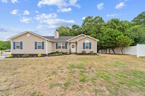 Richlands house for rent - a beige house with blue shutters and a grassy yard