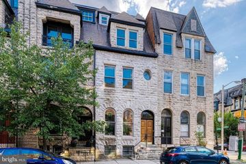 Baltimore apartment for rent - a stone building with blue windows and cars parked in front
