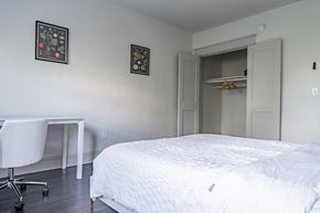 Washington apartment for rent - a bedroom with a bed and a closet and a desk and a chair
