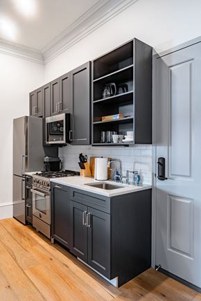 Washington apartment for rent - a kitchen with gray cabinets and a sink and a refrigerator