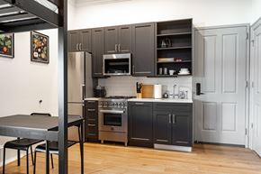Washington apartment for rent - a kitchen with gray cabinets and stainless steel appliances and a table