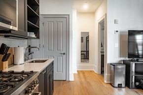 Washington apartment for rent - a kitchen with a sink and a stove and a door to a hallway