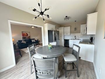 Fayetteville house for rent - A kitchen with a table and chairs in the foreground and a living room in the background.