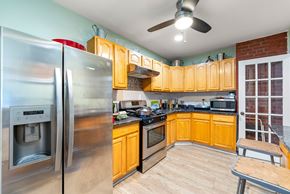 Jersey City apartment for rent - a kitchen with wooden cabinets and stainless steel appliances