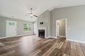 Jacksonville house for rent - A living room with a fireplace and a ceiling fan.