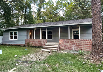 Tallahassee house for rent - a small gray house with a brick porch and a tree