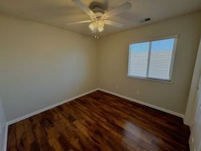 Merced house for rent - a living room with hardwood floors and a ceiling fan
