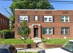 Washington apartment for rent - a red brick house with a black door and a sidewalk