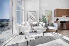 Coquitlam apartment for rent - A modern living room with a large window overlooking a body of water.