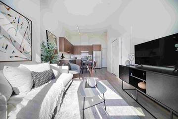 Coquitlam apartment for rent - A modern living room with a white couch and a large abstract painting on the wall.