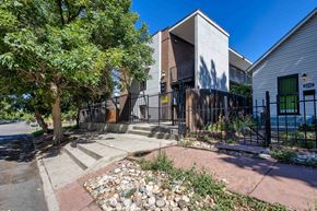 Denver apartment for rent - A modern house with a black gate and a stone pathway leading to the entrance.