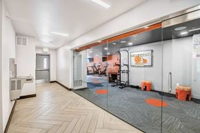 Denver apartment for rent - a room with glass doors and a gym with desks and chairs