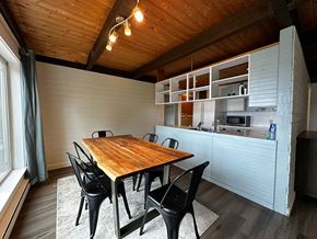 Sitka house for rent - a dining room with a wooden table and a kitchen