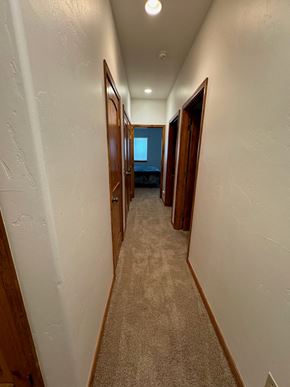 Pagosa Springs house for rent - a hallway with doors and closets and a window