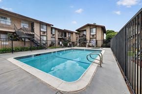 Anaheim apartment for rent - A swimming pool in a residential area surrounded by a fence.