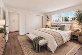 Anaheim apartment for rent - A bedroom with a large bed and a window with blinds.