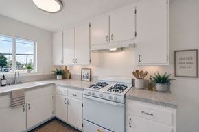 Anaheim apartment for rent - A white kitchen with a stove and cabinets.