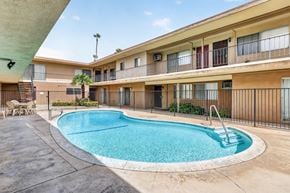 Anaheim apartment for rent - A swimming pool in front of apartment buildings.
