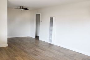 Anaheim apartment for rent - A room with a ceiling fan and a wall-mounted air conditioner unit.