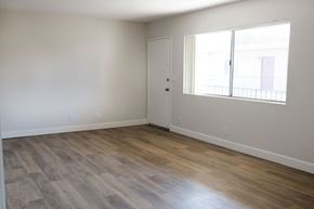 Anaheim apartment for rent - A room with a wooden floor and a window with a view of a building outside.
