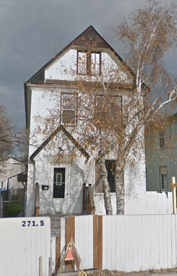 Winnipeg apartment for rent - A white house with a black door and a window is in front of a white fence.
