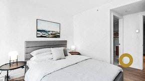 Vancouver house for rent - a white bedroom with a bed and a painting on the wall