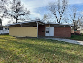 St Louis house for rent - the front of a brick house with a yellow fence