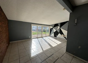 St Louis house for rent - an empty room with a sliding glass door and a tiled floor
