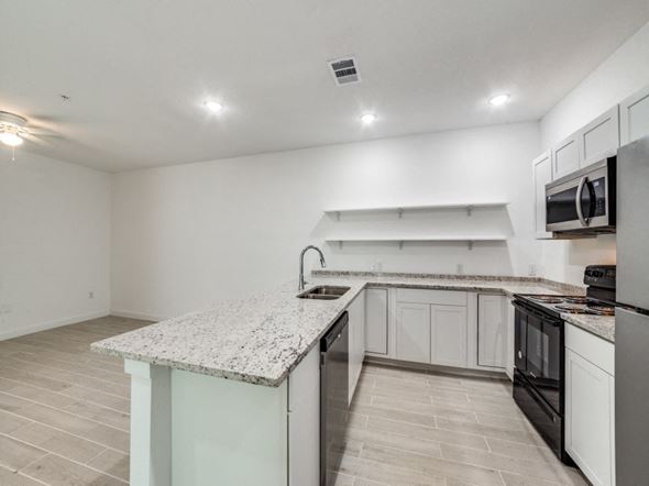 San Antonio apartment for rent - the kitchen of our studio apartment atrium with granite counter tops and black appliances