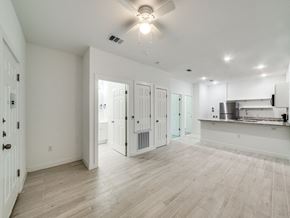 San Antonio apartment for rent - an empty living room with a kitchen and a ceiling fan