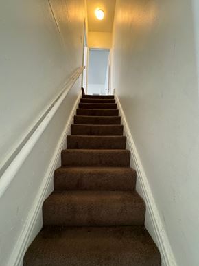 Saint Louis house for rent - a flight of stairs leading up to a hallway with a light on the ceiling