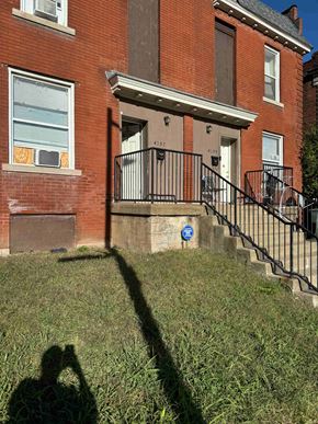Saint Louis house for rent - a shadow of a person in the grass in front of a building