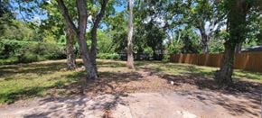 Sweeny house for rent - a backyard with trees and a wooden fence
