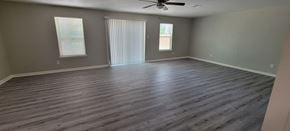 Sweeny house for rent - an empty living room with wooden floors and a ceiling fan