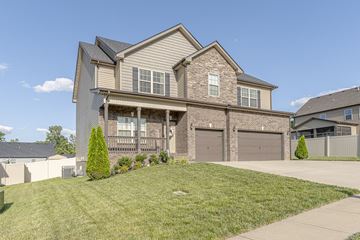 Clarksville house for rent - the front of a house with two garage doors and a lawn
